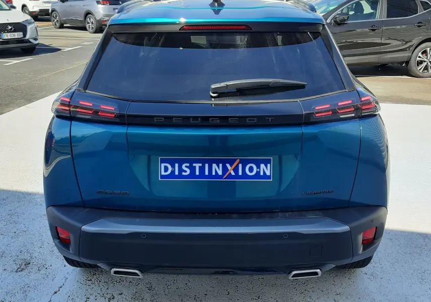 Vue arrière d'un Peugeot 2008 Hybrid 145 Allure bleu obsession, avec feux LED et double sortie d'échappement visible.
