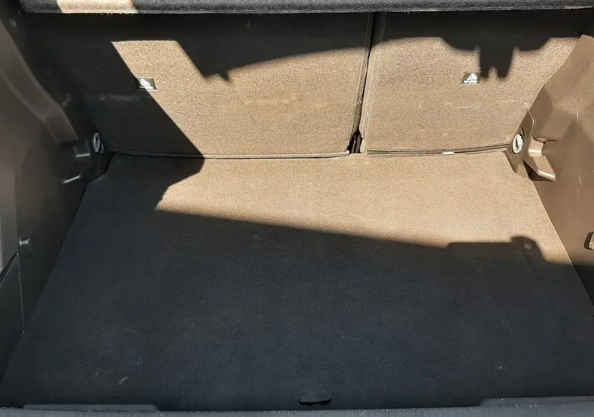 Coffre ouvert vu de face du Peugeot 2008 Hybrid 145 Allure bleu Obsession, espace de rangement vide et propre.