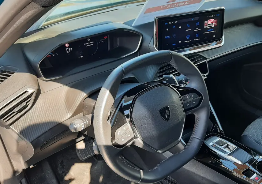 Vue intérieure côté conducteur du Peugeot 2008 Hybrid 145 Allure 2025, tableau de bord numérique et écran tactile central visibles.