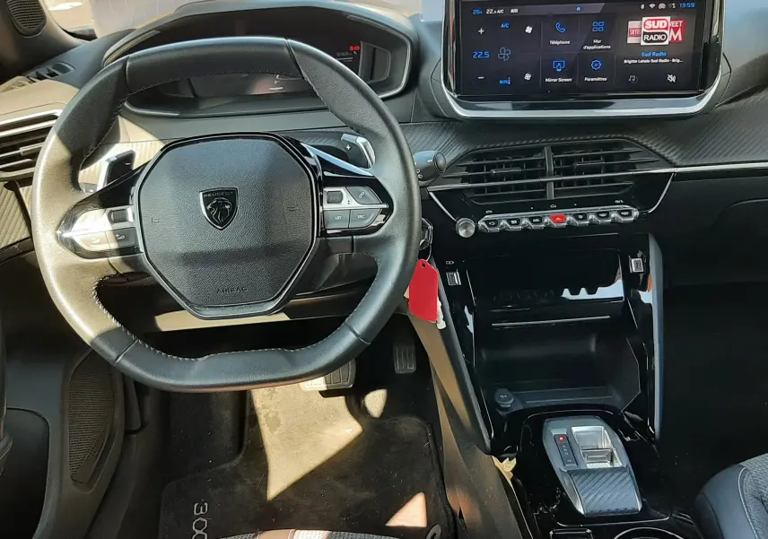 Vue intérieure avant du Peugeot 2008 Hybrid 145 Allure avec tableau de bord numérique et écran tactile central.