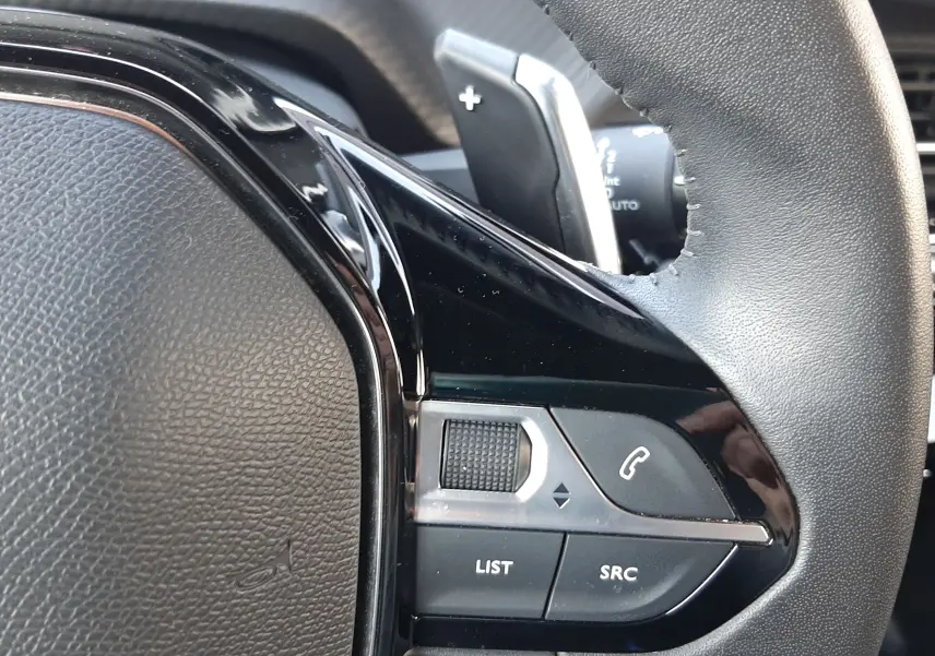 Gros plan sur la partie droite du volant noir du Peugeot 2008 Hybrid 145 Allure 2025 avec commandes intégrées.