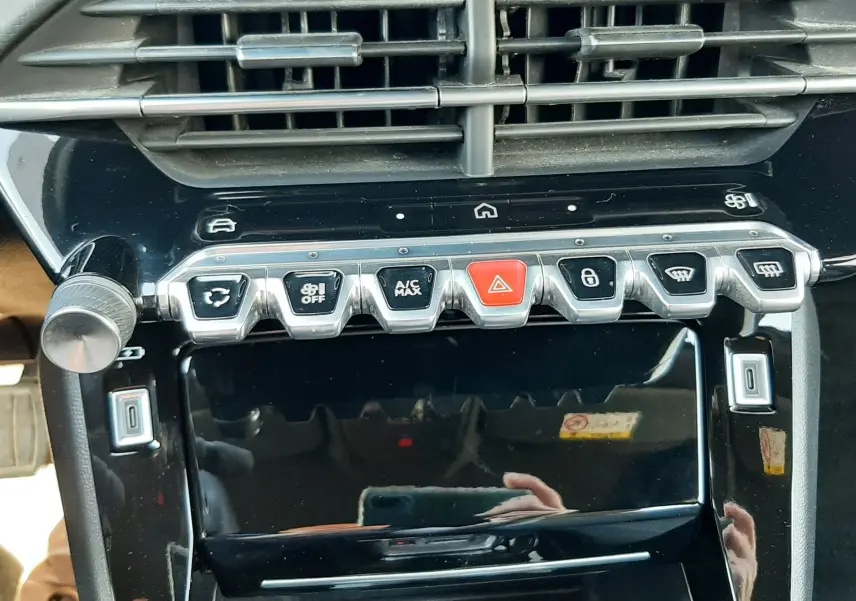 Vue rapprochée de la console centrale noire du Peugeot 2008 Hybrid 145 Allure avec boutons argentés et rouge d’alerte.