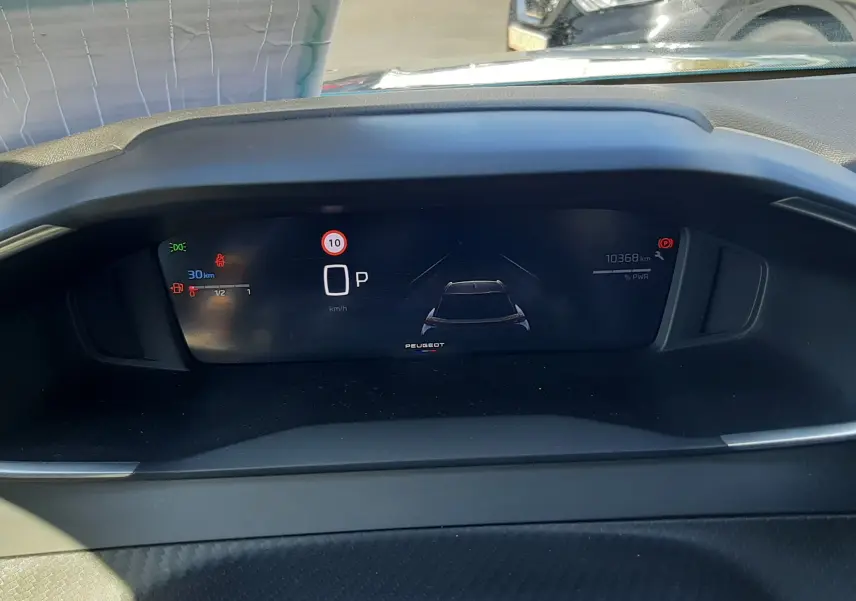 Tableau de bord numérique du Peugeot 2008 Hybrid 145 Allure, affichage de vitesse et autonomie, vue intérieure frontale.
