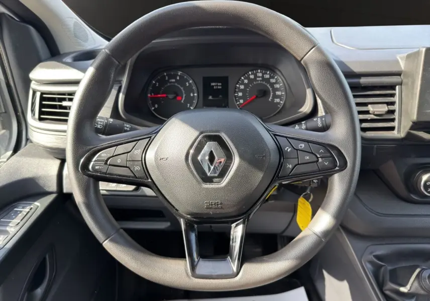 Vue intérieure centrée sur le volant multifonctions noir du Renault Trafic Fourgon avec tableau de bord et commandes visibles.