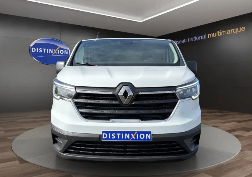Vue frontale d'un Renault Trafic Fourgon blanc 2024 avec calandre noire et phares LED allumés.