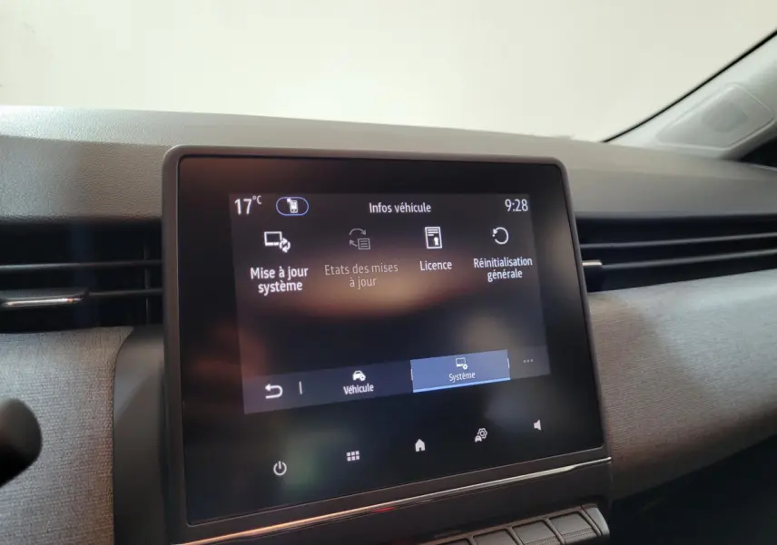 Écran tactile central affichant les options système du tableau de bord d’une Renault Clio gris foncé, vue intérieure.