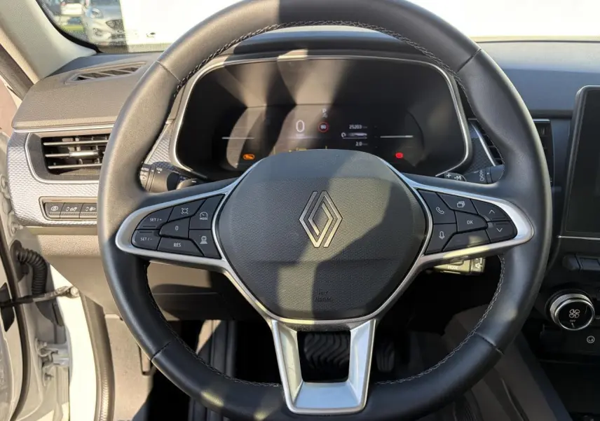 Vue rapprochée du volant noir de la Renault Arkana 2025 avec commandes intégrées et tableau de bord numérique.