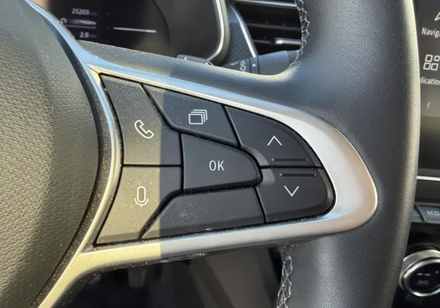 Gros plan sur les commandes au volant côté droit du Renault Arkana 2025, finition noire avec contour argenté.