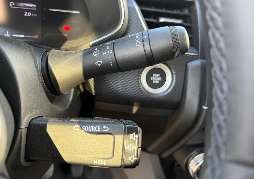 Gros plan sur la commande multimédia et le bouton start/stop du tableau de bord du Renault Arkana 2025.