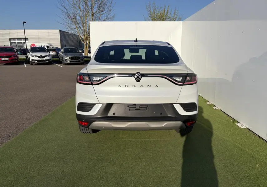 Vue arrière d'un Renault Arkana blanc glacier 2025 avec feux LED reliés par un bandeau lumineux noir.