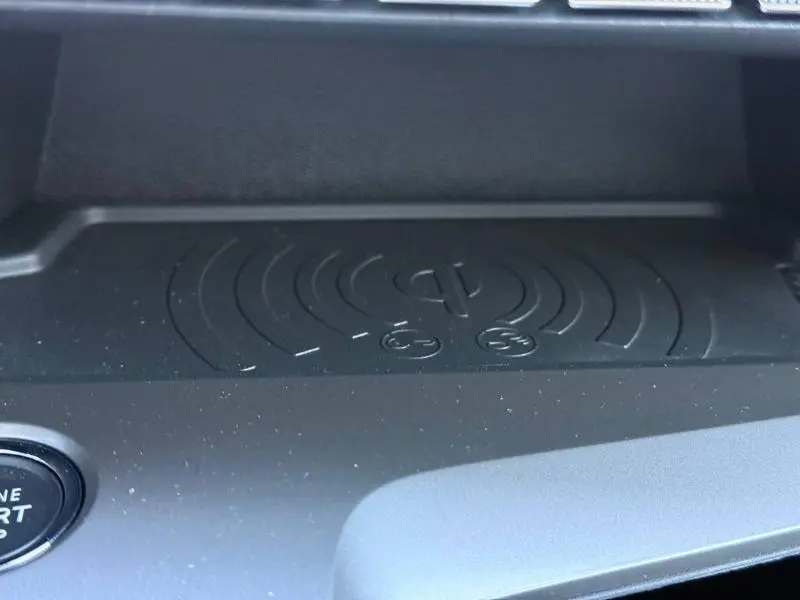 Gros plan sur le support de charge sans fil noir dans l'habitacle du Peugeot 308 gris 1.2 Hybrid 145ch Allure 2025.
