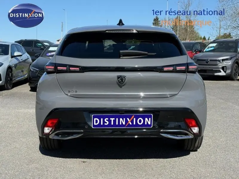 Vue arrière d'une Peugeot 308 gris métallisé 2025 avec feux LED distinctifs et logo noir brillant au centre.
