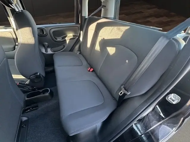 Vue intérieure de la banquette arrière noire de la Fiat Panda 2025, avec ceinture de sécurité et porte côté droit visible.