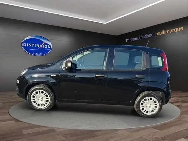 Vue de profil côté gauche d'une FIAT Panda noire 2025 exposée en showroom avec jantes argentées.