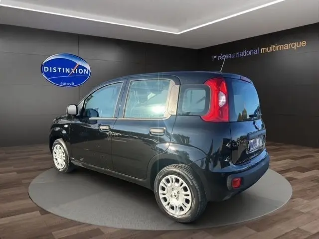 Vue 3/4 arrière droite d'une FIAT Panda noire 2025 avec feux arrière rouges et jantes argentées en présentation showroom.