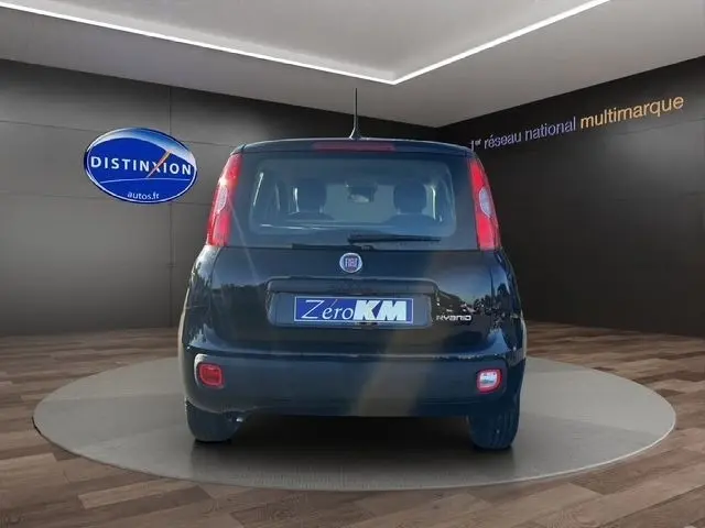 Vue arrière de la FIAT Panda noire 2025, mettant en valeur ses feux verticaux et son logo central sur fond showroom.