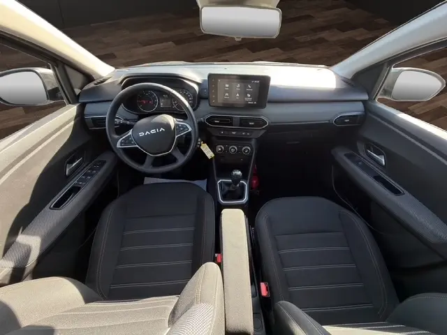 Vue intérieure avant de la Dacia Sandero Stepway gris foncé, avec tableau de bord moderne et écran tactile central.