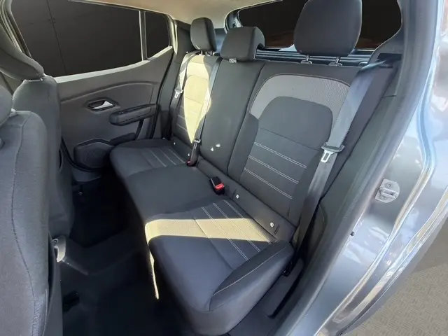 Vue intérieure côté droit sur la banquette arrière grise du Dacia Sandero Stepway 2025 avec ceinture et appuie-têtes visibles.