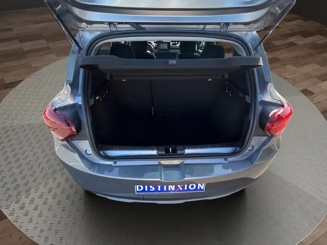 Vue arrière ouverte sur le coffre d'une Dacia Sandero Stepway gris foncé, montrant l'espace de chargement intérieur.