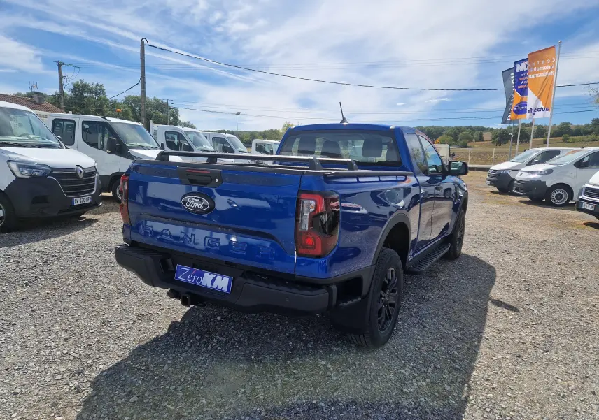 Vue 3/4 arrière droite du Ford Ranger Super Cabine bleu Lightning avec rideau de plateau et barres sur plateau.