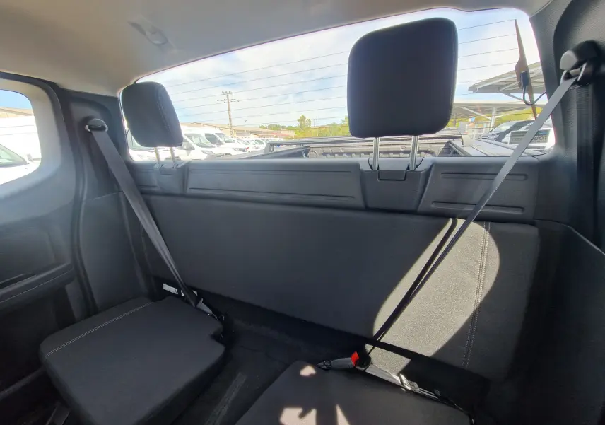 Vue intérieure arrière du Ford Ranger Super Cabine bleu Lightning, montrant les sièges arrière et la fenêtre du plateau avec rideau rigide.