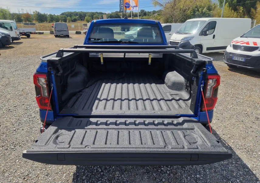 Vue arrière du Ford Ranger Super Cabine bleu Lightning avec plateau ouvert et rideau rigide coulissant visible.