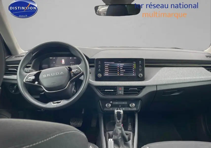 Vue intérieure avant du Skoda Kamiq gris 2025, tableau de bord moderne avec écran tactile et volant multifonction cuir.