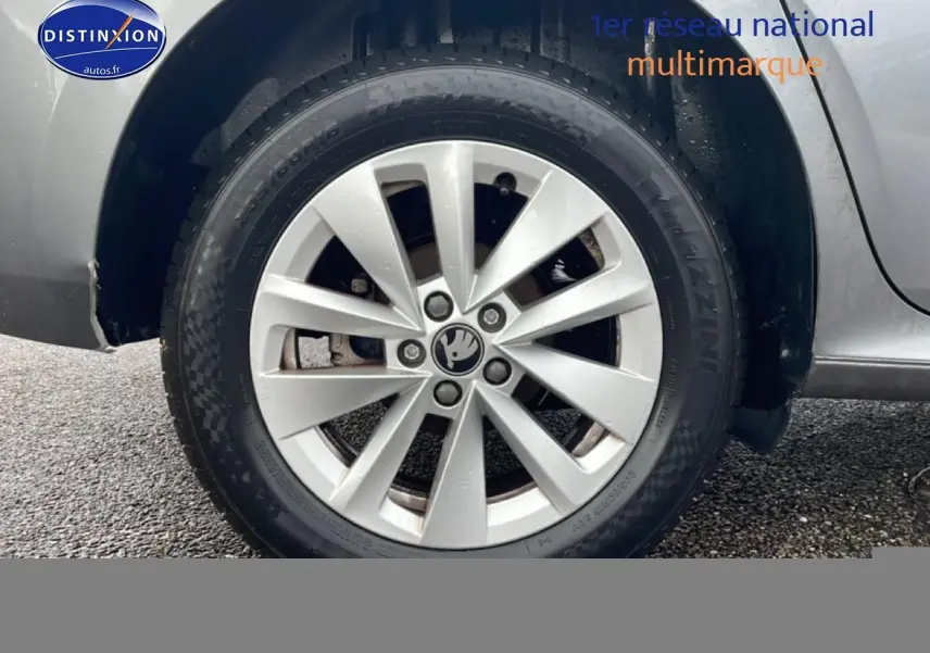 Gros plan sur la roue avant droite gris métallisé du Skoda Kamiq 2025 avec jante alu et logo Skoda au centre.