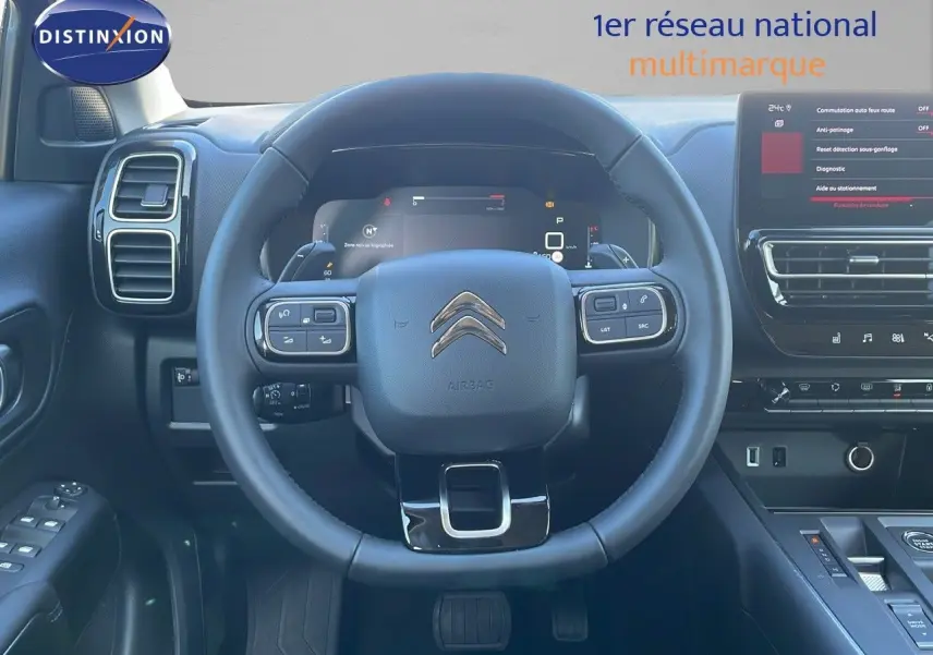 Vue intérieure centrée sur le volant du Citroën C5 Aircross 2025, avec tableau de bord et écran tactile visibles.