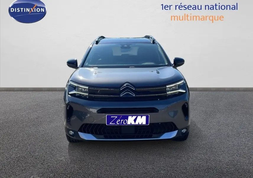 Vue frontale d'un Citroën C5 Aircross 2025 gris platinium métal avec toit noir et signature lumineuse LED distinctive.