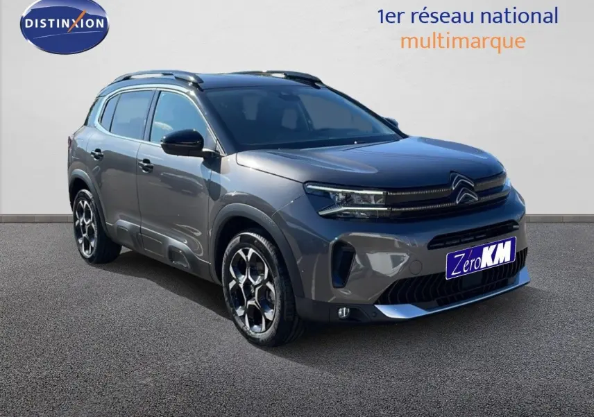 Vue 3/4 avant d'un Citroën C5 Aircross gris platinium avec toit noir, jantes bi-ton et calandre moderne.
