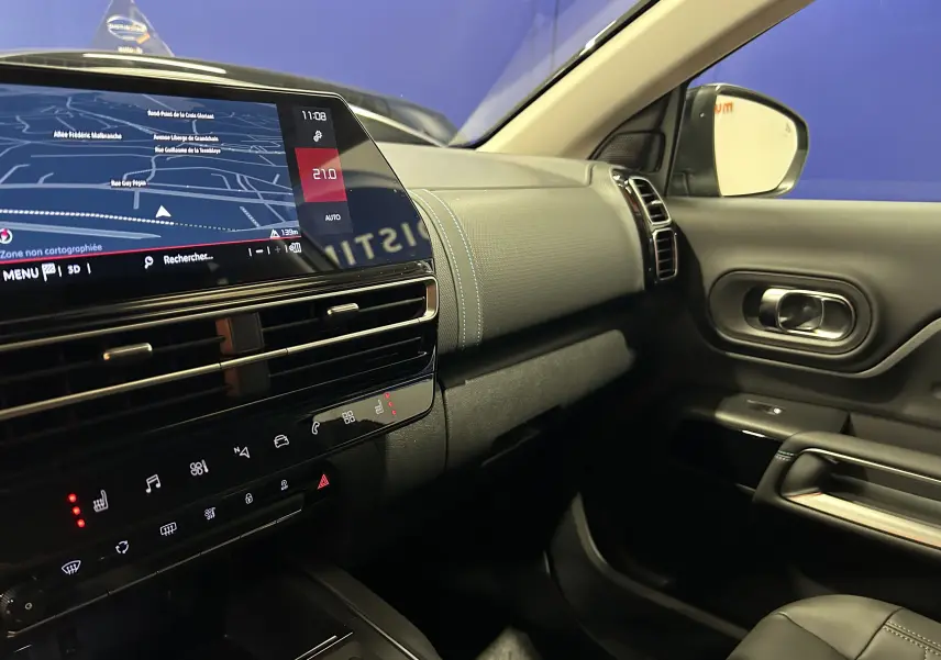 Vue intérieure côté passager du tableau de bord et console centrale du Citroën C5 Aircross 2025 avec écran tactile et sellerie noire.