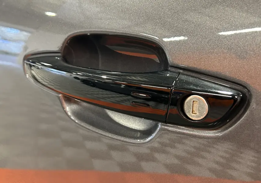 Poignée de porte noire en gros plan sur la portière gris platinium métallisé d'une Citroën C5 Aircross 2025.