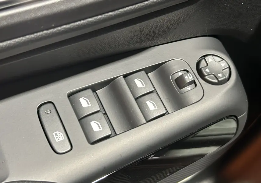 Gros plan sur les commandes des vitres électriques côté conducteur du Citroën C5 Aircross gris platinium 2025.
