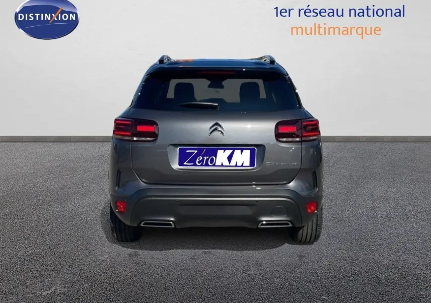 Vue arrière d'un Citroën C5 Aircross gris platinium métal avec toit noir, mettant en valeur ses feux LED et double sortie d'échappement.