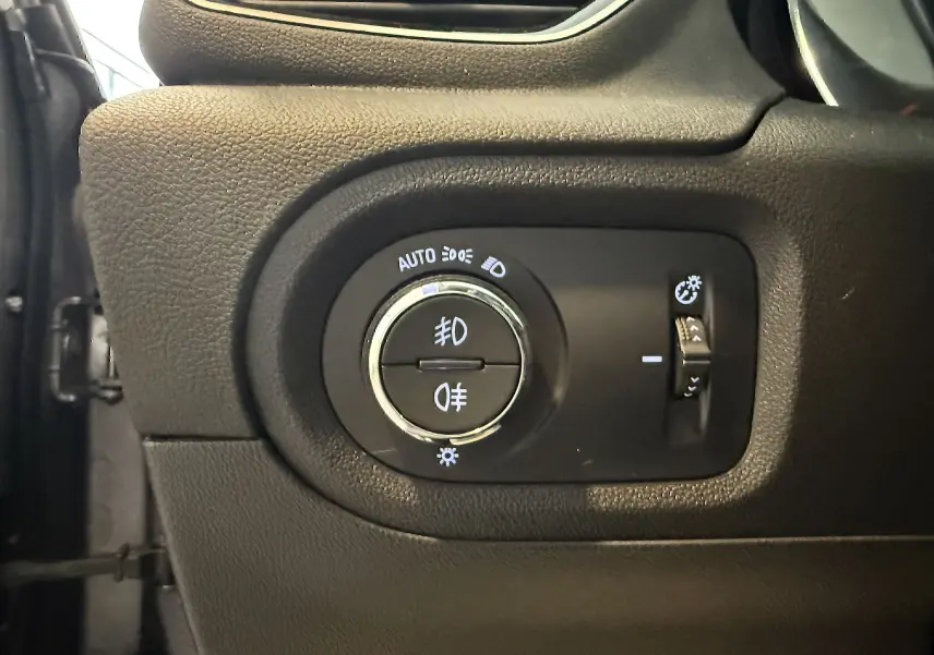 Gros plan sur le sélecteur d'éclairage noir du tableau de bord de l'Opel Grandland X gris Himalaya 2021.