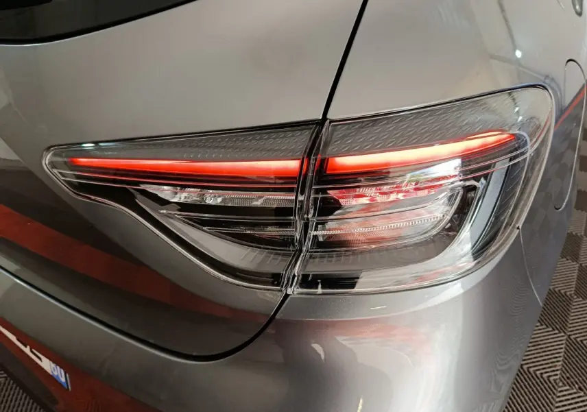 Gros plan sur le feu arrière droit allumé d’une Renault Clio gris clair Evolution Blue dCi 100 -25.