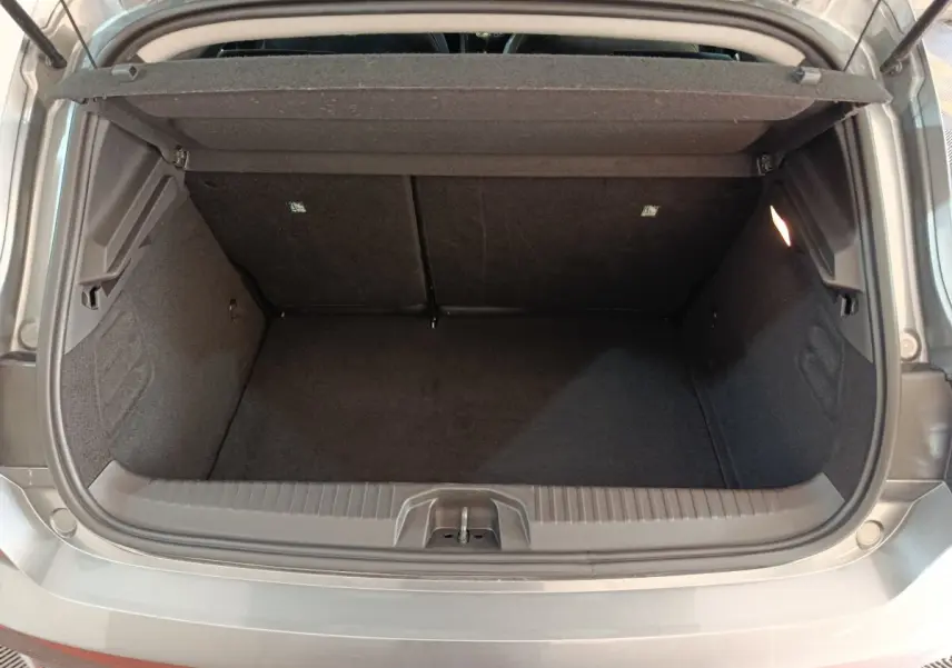 Coffre ouvert vu de l'arrière d'une Renault Clio gris clair 2025, montrant l'espace de chargement vide et la tablette arrière.