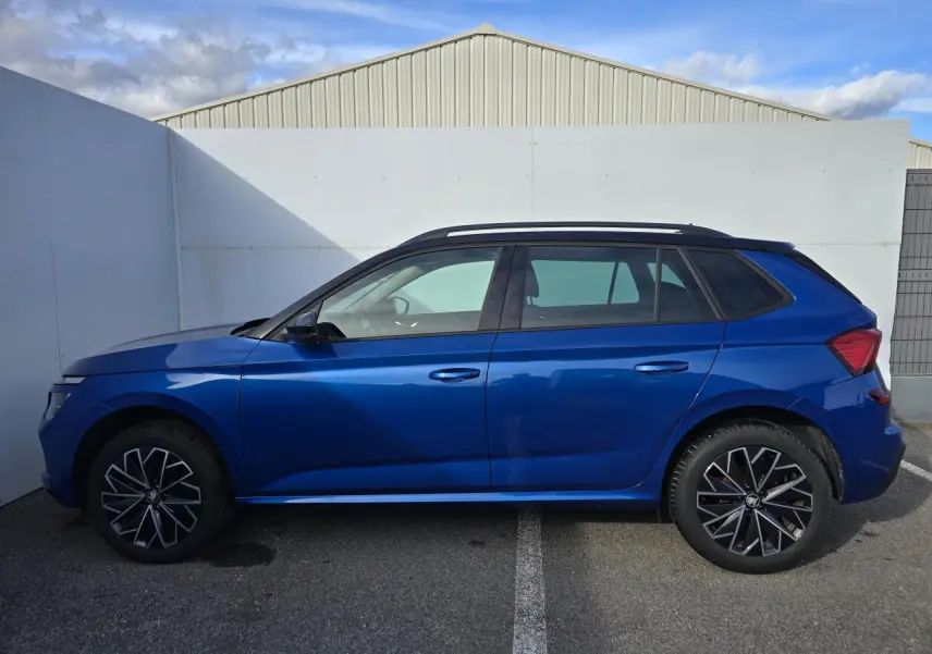 Vue de profil côté gauche d'un Skoda Kamiq bleu racing avec toit noir et jantes alliage 17 pouces.
