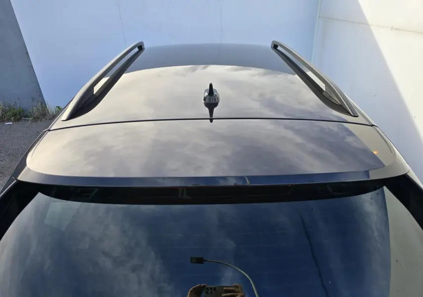 Vue plongeante sur le toit noir brillant et barres de toit du Skoda Kamiq bleu Racing 2025.