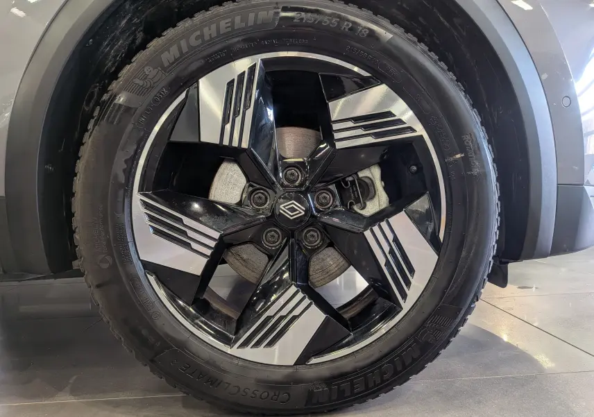 Gros plan sur la roue avant droite du Renault Symbioz gris Cassiopé, jante noire et argent au design géométrique.