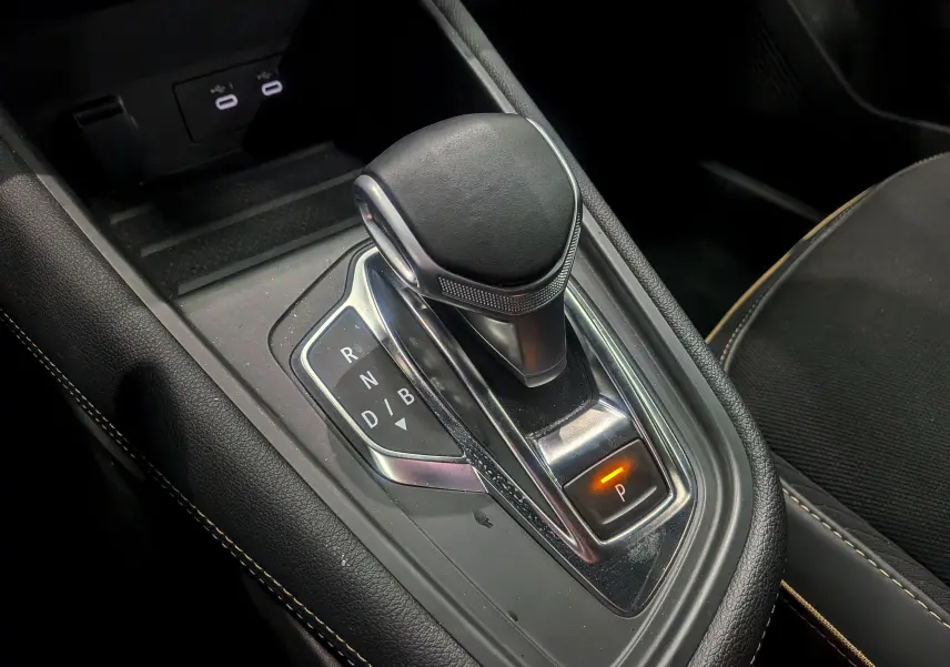Gros plan sur le levier de vitesses automatique noir de la Renault Symbioz gris Cassiopé, avec mode parking activé.