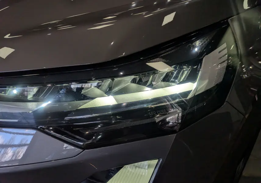 Gros plan sur le phare avant droit LED du Renault Symbioz gris Cassiopé, mettant en valeur son design moderne et précis.