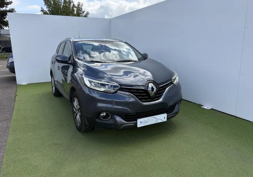 Renault Kadjar gris titanium en 3/4 avant droit, avec calandre chromée et jantes alliage 17 pouces.
