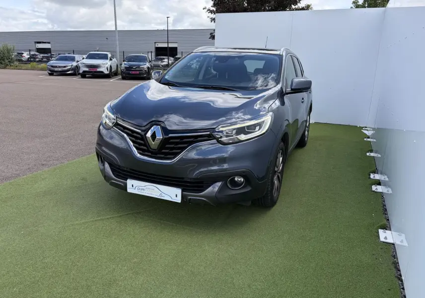 Renault Kadjar bleu métal en 3/4 avant droit, avec projecteurs LED et calandre chromée visible.