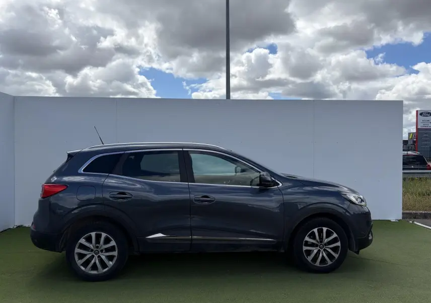 Profil droit du Renault Kadjar bleu métal 2016 avec jantes alliage 17 pouces et vitres surteintées.