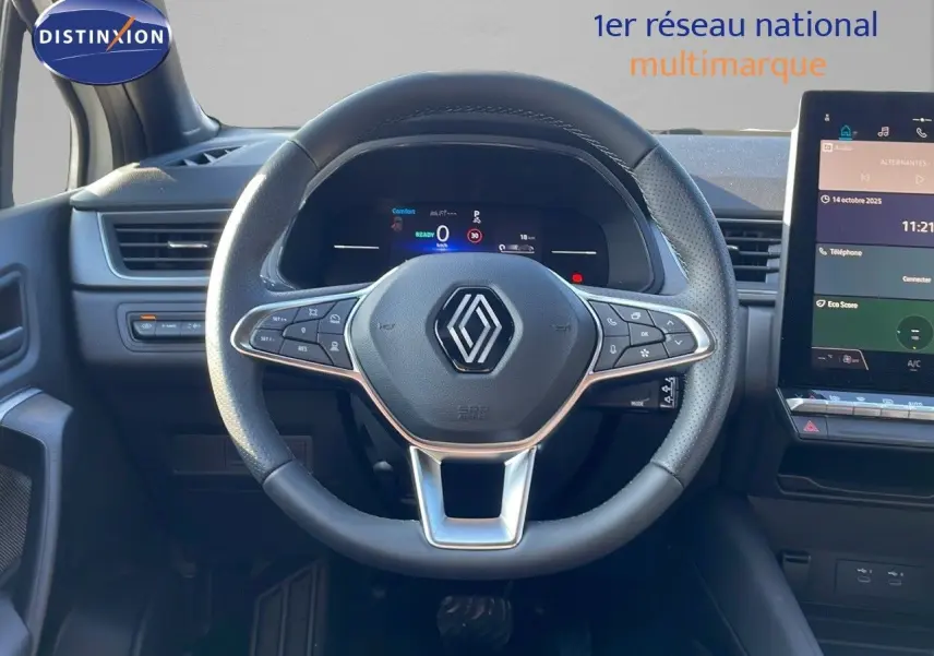 Vue intérieure centrée sur le volant Renault du Captur E-Tech hybride 2025 avec tableau de bord digital et écran tactile.