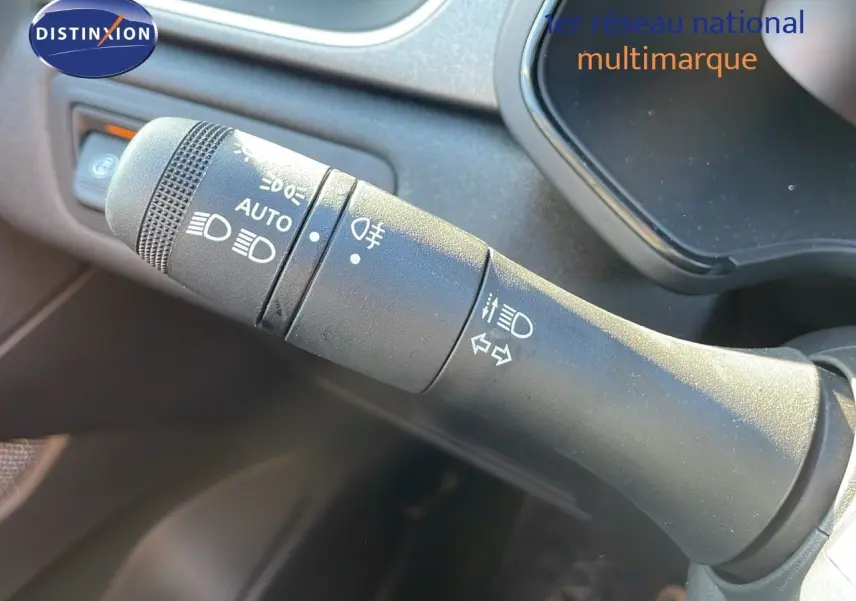 Gros plan sur la commande des phares et clignotants dans l'habitacle du Renault Captur blanc nacré 2025.