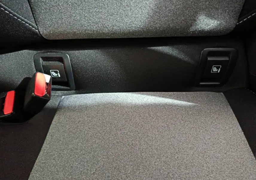 Détail de la banquette arrière grise de la Renault Clio Evolution Blue dCi 100 avec fixations Isofix et boucles de ceinture rouges.