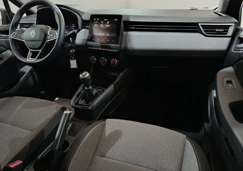 Vue intérieure avant de la Renault Clio Evolution Blue dCi 100 2025, tableau de bord gris clair avec écran tactile central et volant multifonctions.